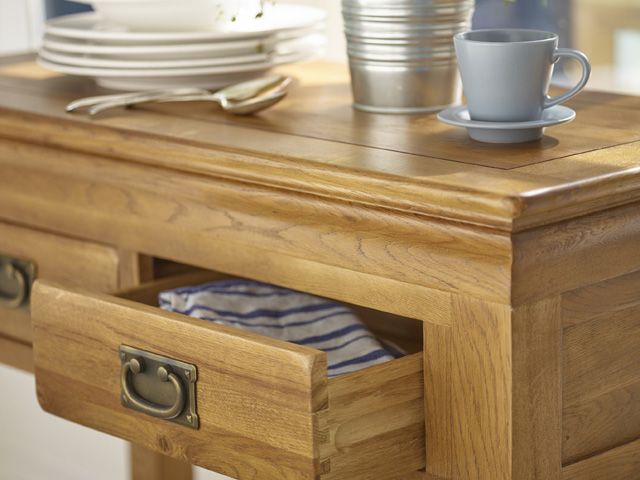 法式农家乐风格的木质控制台桌由橡木家具组合而成，上面有杯子、金属花盆和餐具