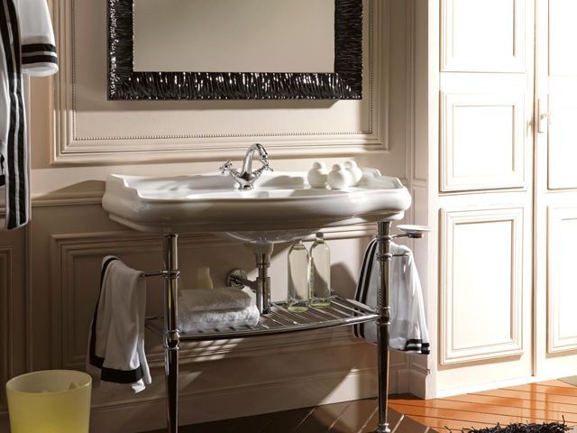 albion浴室在镀铬物的纸块纸刀盆在一个小浴室的镀铬物与黑框架镜子