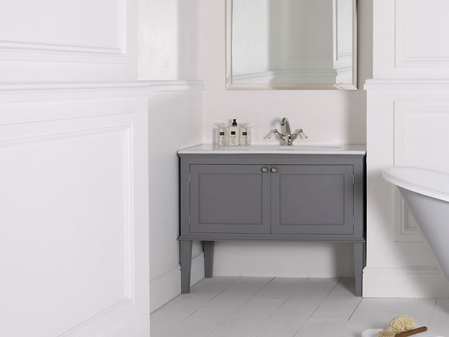 与水槽的灰色哈马尔梳妆台控制台在一个全白色的卫生间里