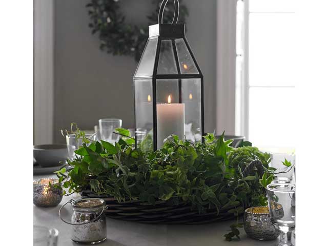 白色公司聊天和大柱蜡烛灯笼在圣诞节主题的餐桌上的花圈