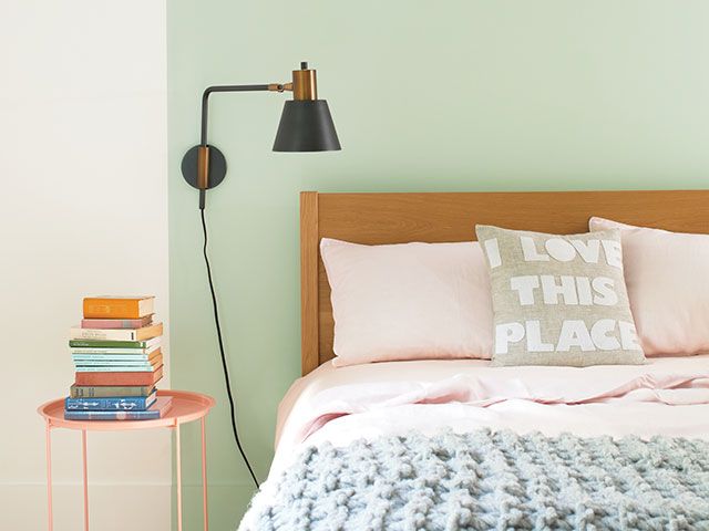 卧室涂上绿色的墙和墙灯——goodhomesmagazine.com