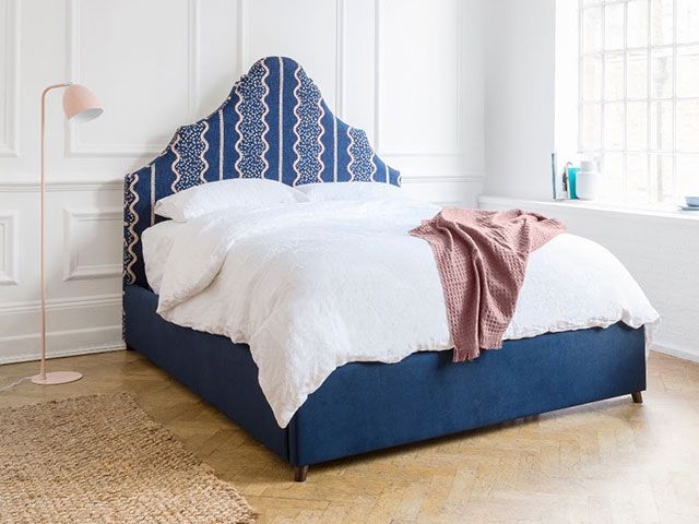 沙发和东西弯曲的床头板和蓝色和粉红色模式——goodhomesmagazine.com