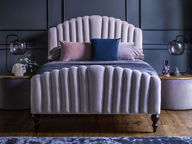 在灰色的圆齿状的软垫床,蓝色的卧室——goodhomesmagazine.com