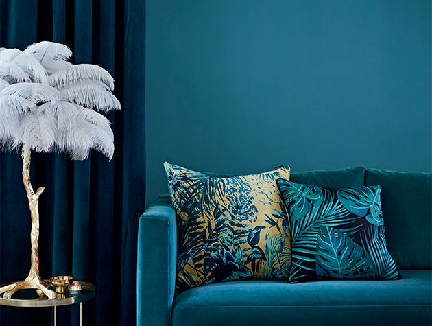 蓝色的沙发和靠垫，蓝色的墙和窗帘