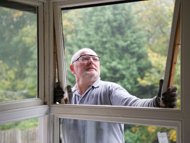 戴防护眼镜的人正在修窗户