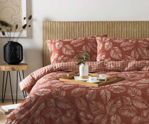 red japanese inspired bedding on wicker bed - japandi interiors trend - goodhomesmagazine.com