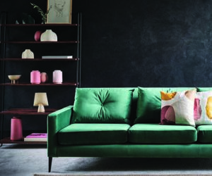 木制架子上的绿色沙发和粉色花瓶，goodhomesmagazine.com