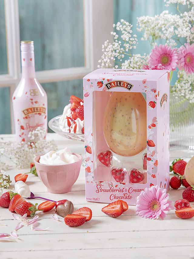 用草莓包裹着白巧克力的复活节彩蛋和粉红色和白色的花束
