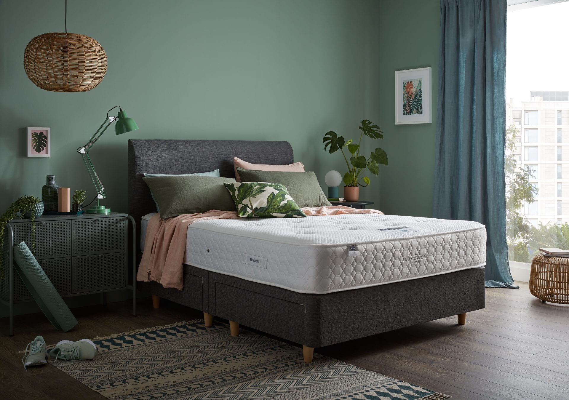 grey bed and white mattress in a green bedroom