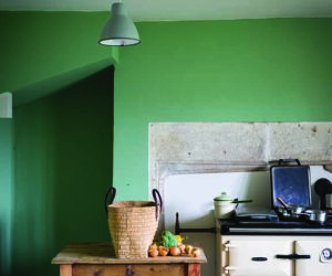 明亮的绿色厨房，灯光和编织篮在桌子上，goodhomesmagazine.com