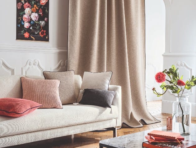 当代室内白色沙发，彩色坐垫和米色百叶窗直接窗帘