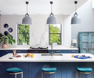 厨房岛台有三把蓝色椅子，吊灯和早餐