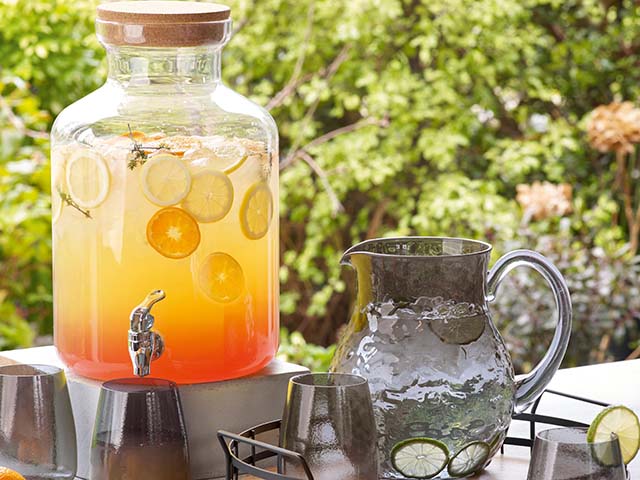 橙汁饮料在绿叶花园设置- goodhomesmagazine.com