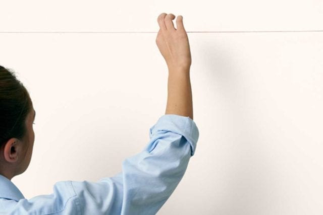 女人用一根绳子敲击墙壁——画过的床头板——Goodhomesmagazine.com