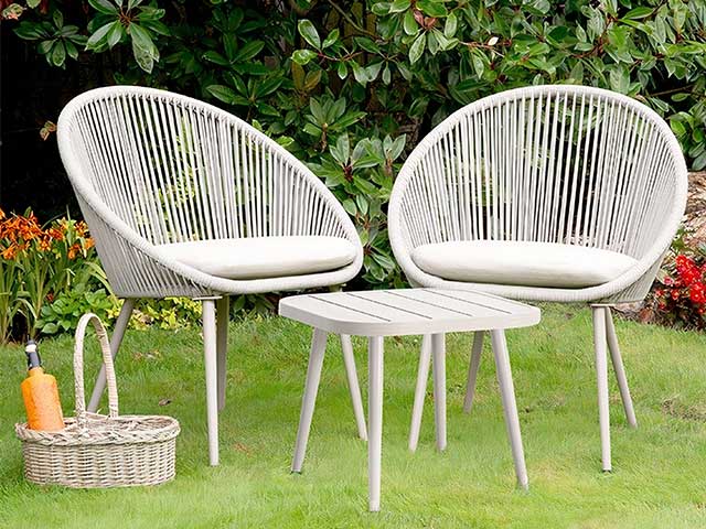 两个圆形的白色蛋椅和草地上的一张匹配的小咖啡桌 -  2021花园家具 -  Goodhomesmagazine.com