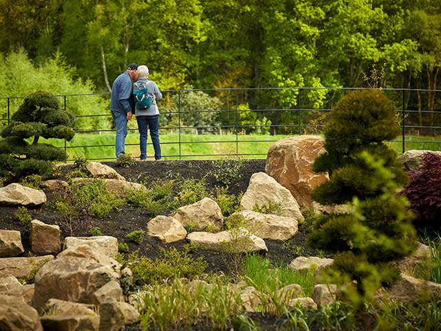 两个人在一座桥上在一个风景如画的花园-英国天- Goodhomesmagazine.com