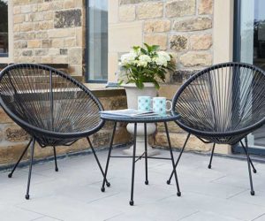 一个现代的庭院花园，配有两把配套的黑色鸡蛋椅和一张咖啡桌，上面放着两个马克杯——2021年的花园家具- Goodhomesmagazine.com