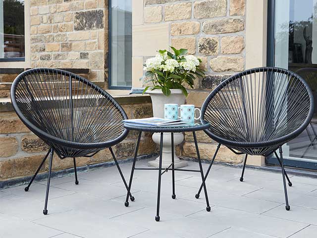现代庭院花园，有两种匹配的黑色蛋椅和一张咖啡桌，有两个杯子 -  2021花园家具 -  Goodhomesmagazine.com