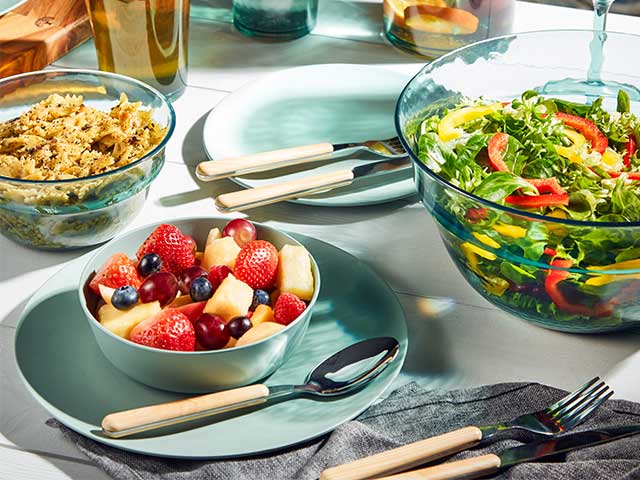 薄荷绿色的盘子和配套的碗上面装满了水果-烧烤周必需品- Goodhomesmagazine.com
