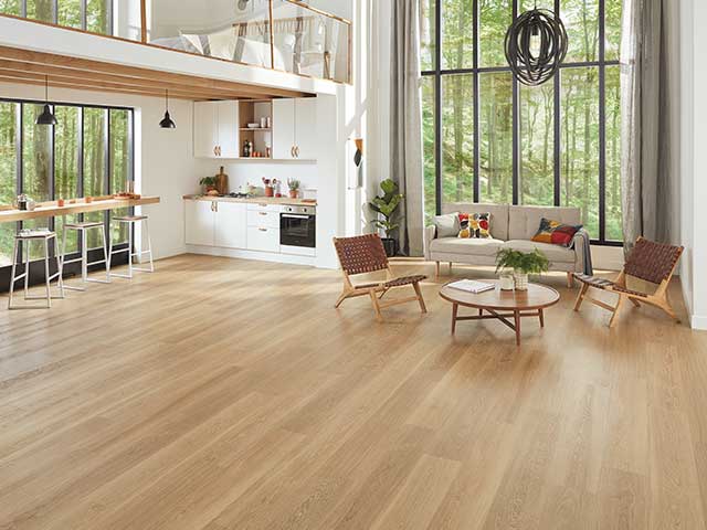 一个大房间的座位在远端和木制风格的地板- 2021地板趋势- Goodhomesmagazine.com
