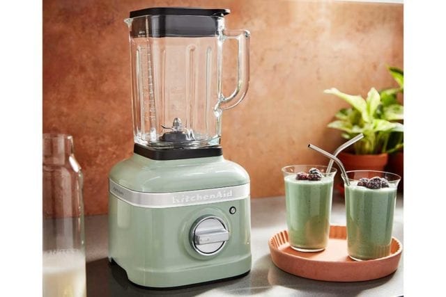 复古风格的薄荷绿搅拌机放在工作台上，旁边放着两个装满绿色冰沙的玻璃杯-厨房小玩意-goodhomemagazine.com
