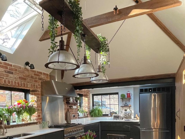modern country kitchen with exposed-brick walls, skylight and wooden ceiling beams