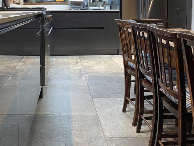 modern country kitchen with sleek dark gloss cabinets and rustic flagstone flooring