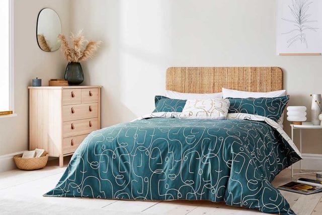 一间卧室，带有编织木质床头板和一个带有单线连续图案的抽象面的卧室 - 大胆床上用品 -  Goodhomesmagazine.com