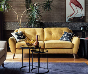 客厅的黄色针垫双人沙发，蓝色的地毯和黑色的边桌