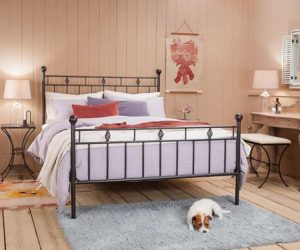 维多利亚风格的黑色铁制床架，床前地毯上放着一只狗——铁床——Goodhomesmagazine.com