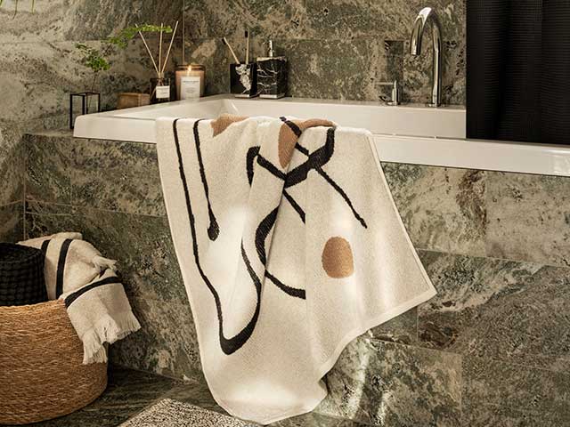 灰色陶瓷大理石浴缸用的奶油毛巾挂在一边