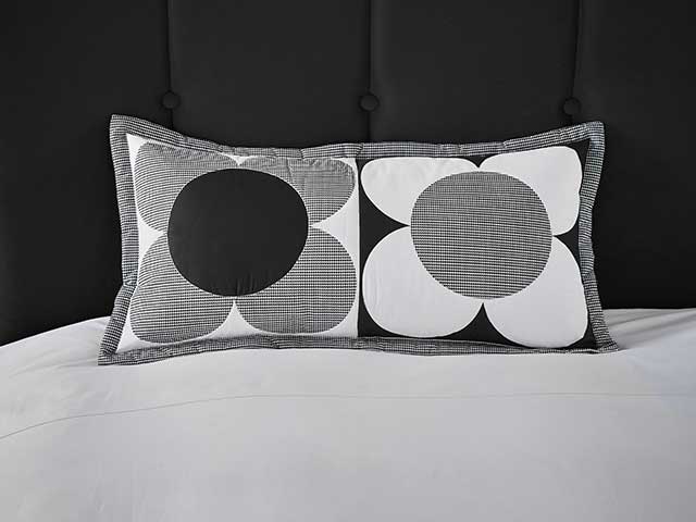 Monochrom花黑色和白色的垫子在黑色枕形床头板和白色的床上用品