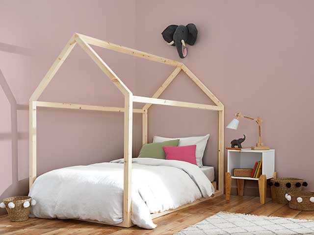 粉红色的房间挂着大象和木制框架的床受斯泰西所罗门的粉红色的托儿所