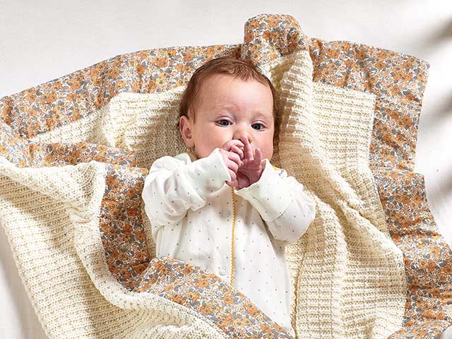 宝宝在花奶油毯子从劳拉阿什利托儿所收集