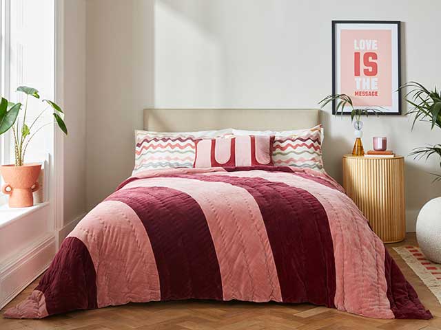 卧室设置与室内植物和墙艺术条纹床单